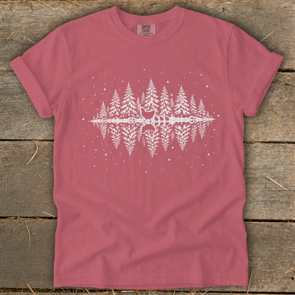 Pink t-shirt with white graphic of pine trees reflecting in water, with chickens.