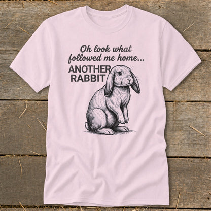 Pink t-shirt with a drawing of a rabbit and text that reads "Oh look what followed me home... ANOTHER RABBIT".