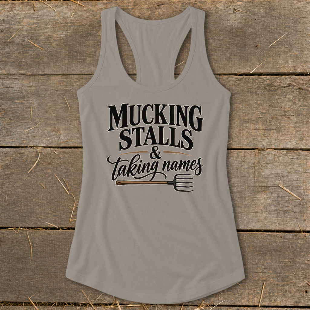 Gray tank top with text "MUCKING STALLS & Taking names" and a pitchfork.