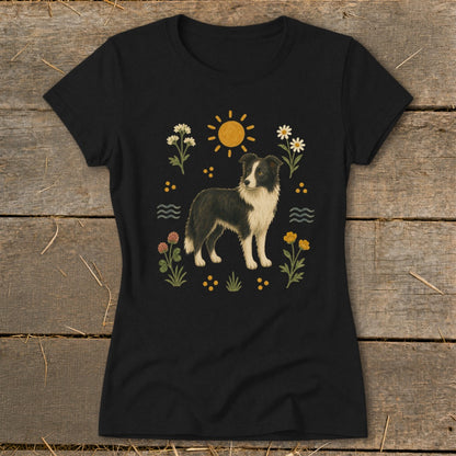 Black t-shirt with a border collie dog illustration surrounded by flowers, sun, and waves.