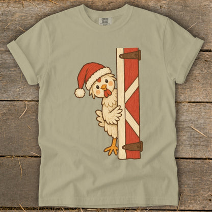 Cartoon chicken wearing Santa hat peeking around a red barn door.