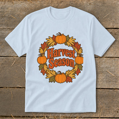 Light blue t-shirt with "Harvest Season" text inside a pumpkin and fall leaf wreath.
