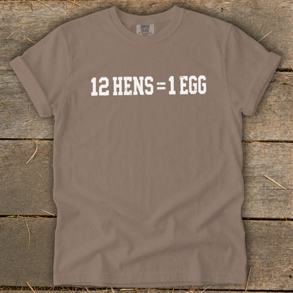 A brown short-sleeve t-shirt with the white distressed text "12 HENS = 1 EGG" printed on the front.