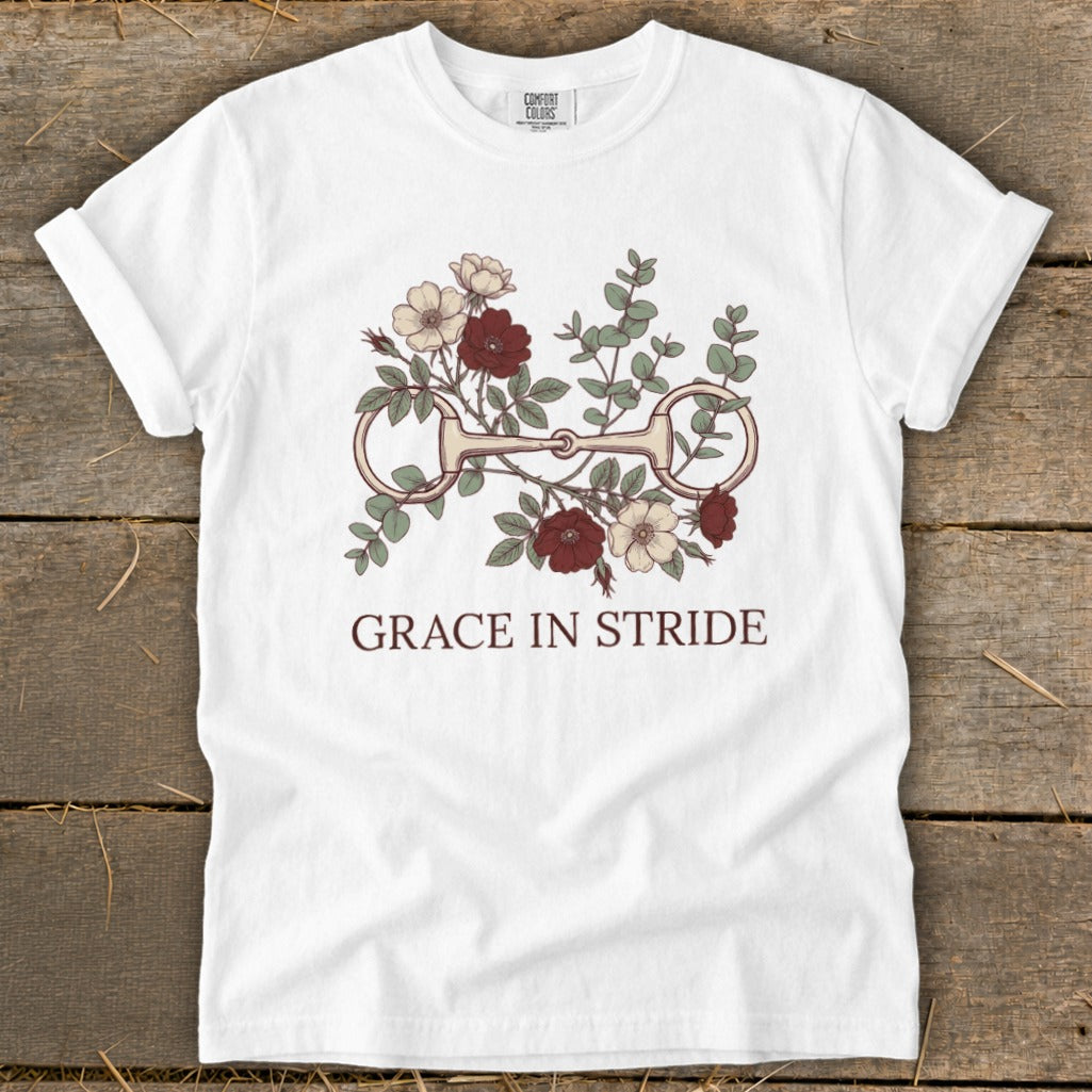 White t-shirt with floral design and horse bit, text "GRACE IN STRIDE".