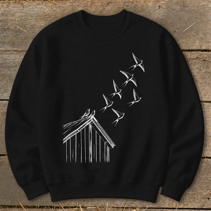 Black crewneck sweatshirt featuring a white sketch of a birdhouse with swallows flying upward from the roof.
