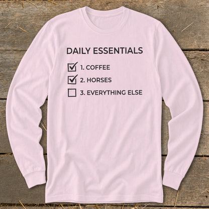 Pink long-sleeve shirt with "Daily Essentials" checklist: 1. Coffee, 2. Horses, 3. Everything Else.