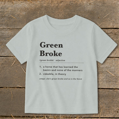 Light gray short-sleeve t-shirt with black dictionary definition text reading Green Broke on a rustic wooden background.
