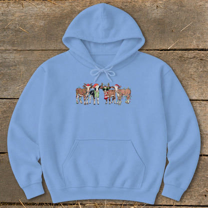 Light blue hoodie with a festive cow graphic wearing Christmas hats and lights.