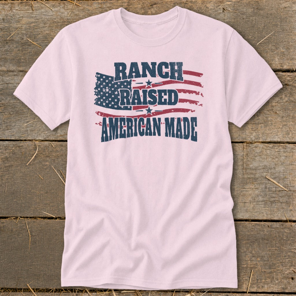 Pink t-shirt with distressed American flag graphic and text "RANCH RAISED AMERICAN MADE".