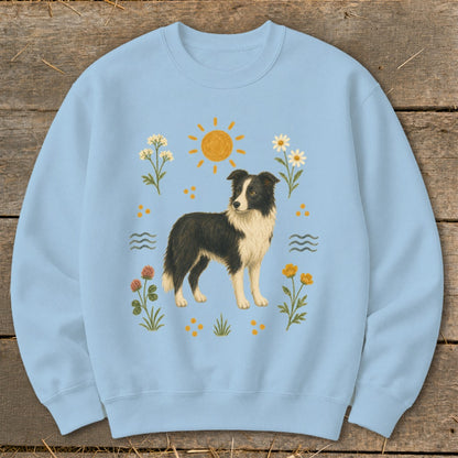Light blue sweatshirt with a Border Collie dog, sun, and floral print.
