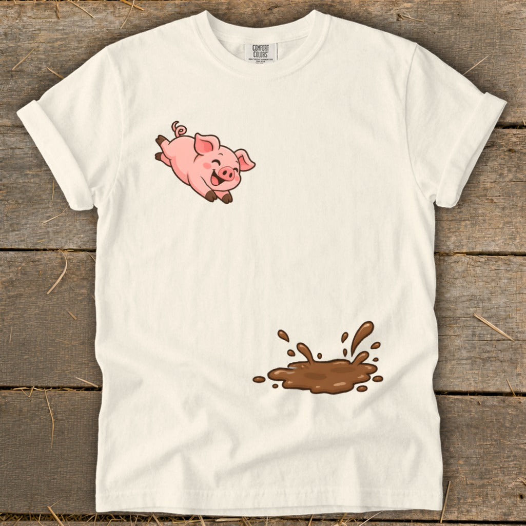 White t-shirt with a cartoon pig jumping over a splash of mud.