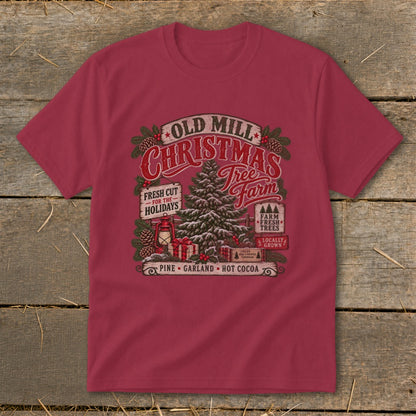 "Old Mill Christmas Tree Farm" graphic with vintage elements on a burgundy t-shirt.