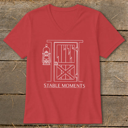 Red v-neck shirt with white line art of a barn door and lantern, reading "STABLE MOMENTS".