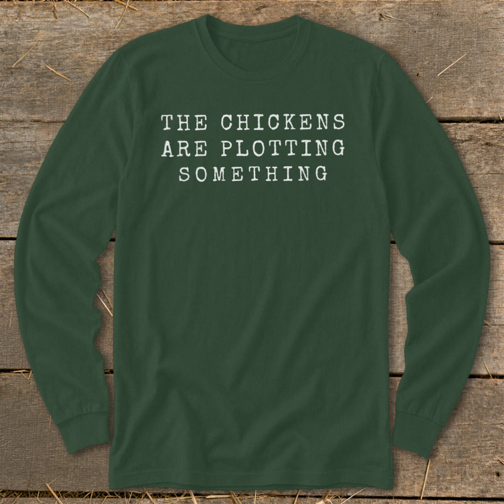 Dark green long-sleeve shirt with white text that reads "THE CHICKENS ARE PLOTTING SOMETHING".