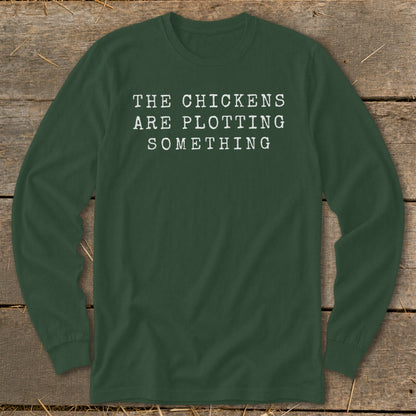Dark green long-sleeve shirt with white text that reads "THE CHICKENS ARE PLOTTING SOMETHING".