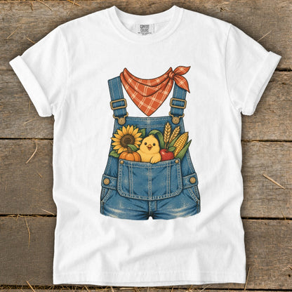 White t-shirt with denim overalls design featuring a chick, sunflower, pumpkin, corn, and apple.