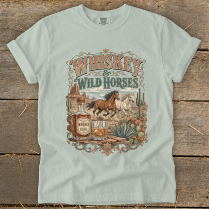 Whiskey & Wild Horses graphic on a light blue t-shirt with desert imagery.