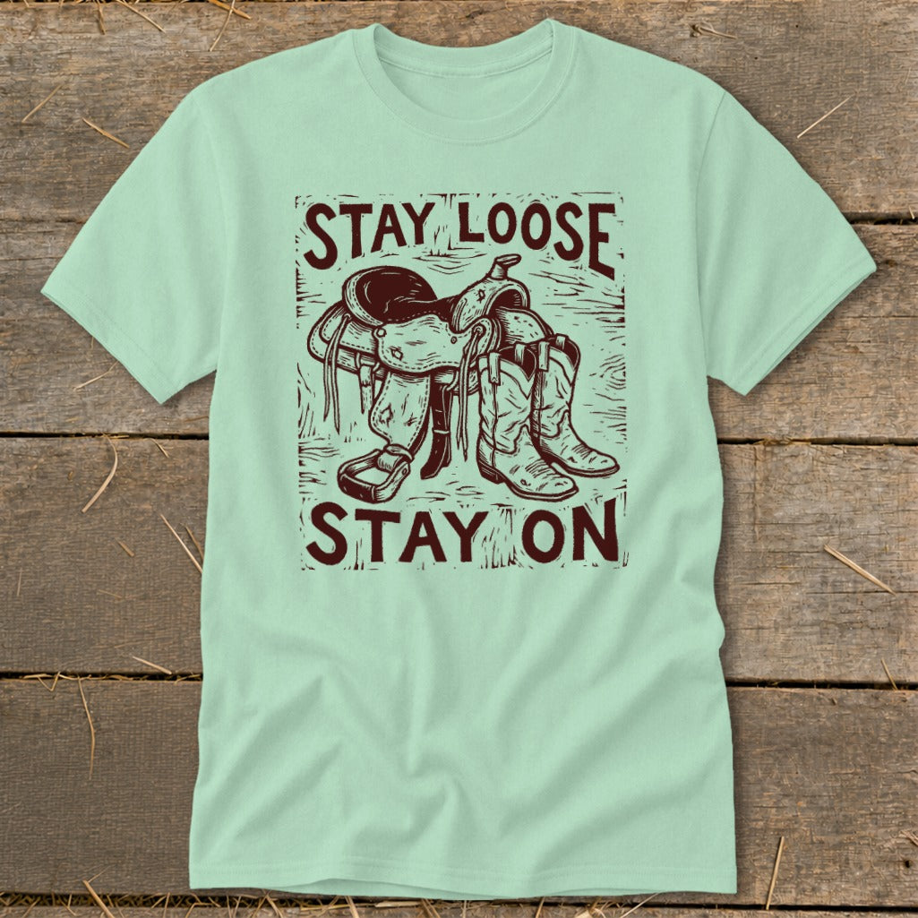 Light green t-shirt with saddle, boots, and "Stay Loose Stay On" text.