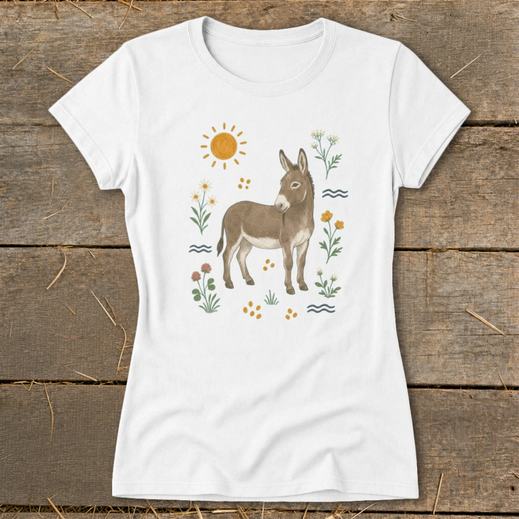 White t-shirt with a watercolor illustration of a donkey surrounded by flowers and a sun.