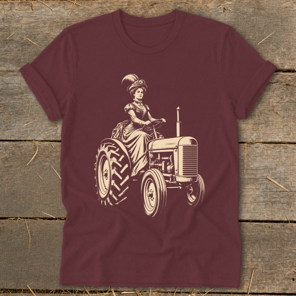Woman in vintage dress driving a tractor, cream illustration on burgundy shirt.