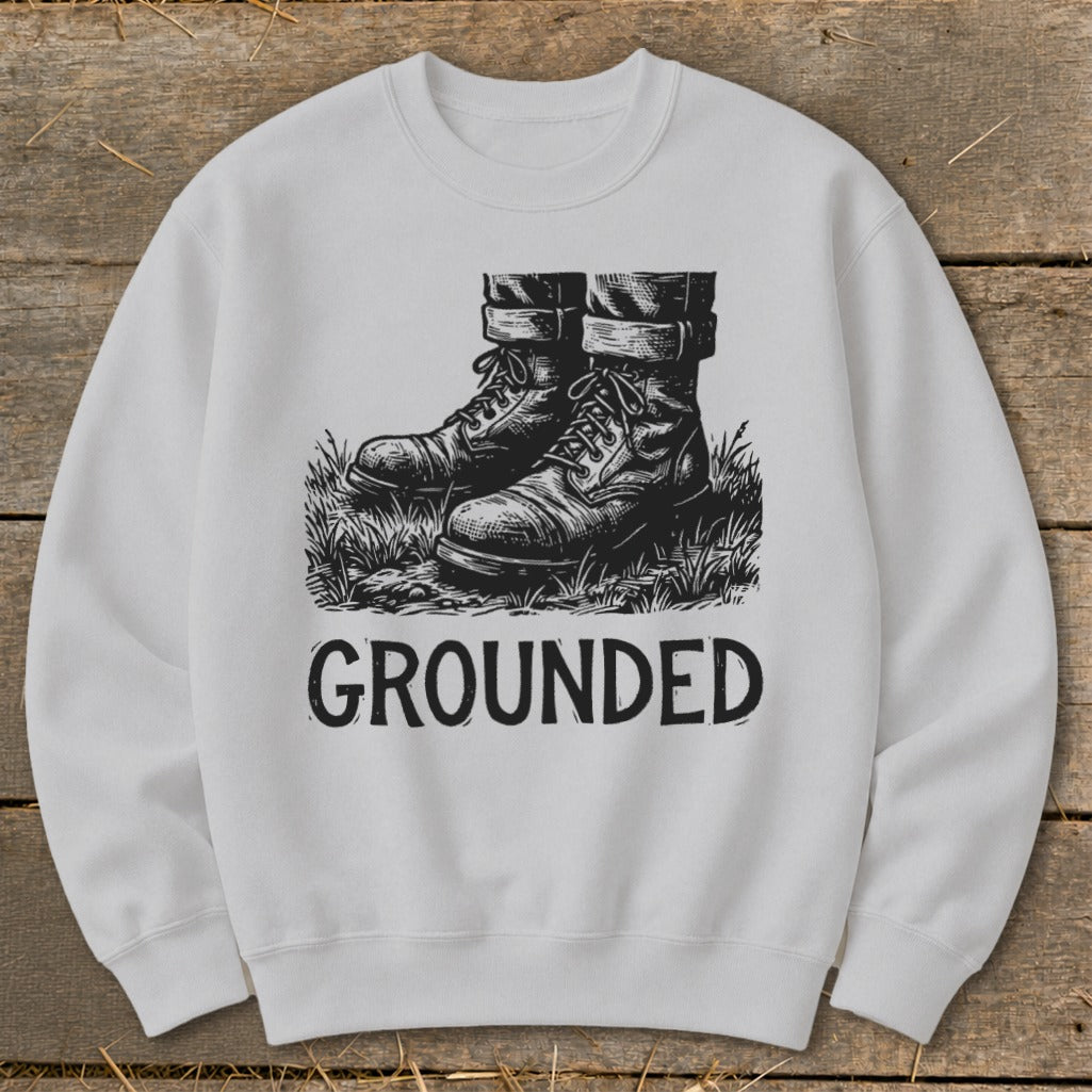 White sweatshirt with black graphic of boots in grass and the word "GROUNDED".