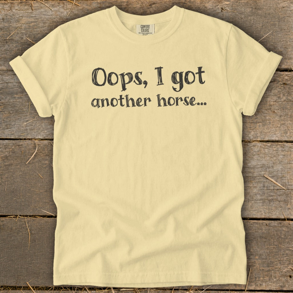 Light yellow t-shirt with black text reading "Oops, I got another horse...".
