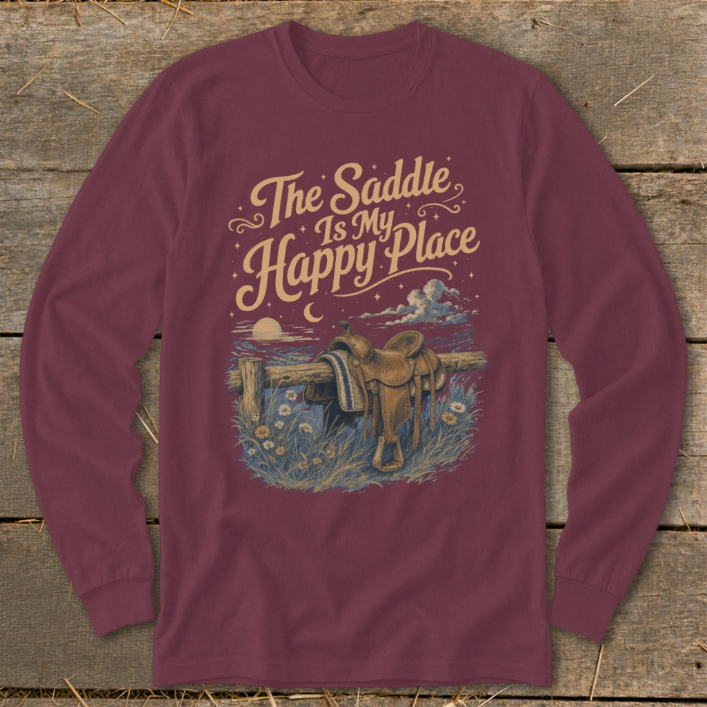 Maroon long-sleeved shirt with a graphic featuring a saddle on a fence, flowers, and text that reads The Saddle Is My Happy Place.