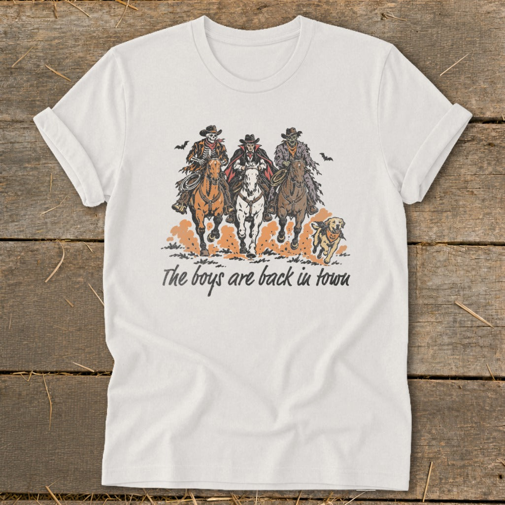 Three cowboys and a dog ride horses with text "The boys are back in town."