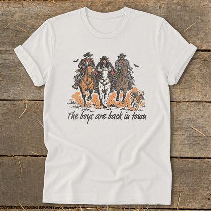 Three cowboys and a dog ride horses with text "The boys are back in town."
