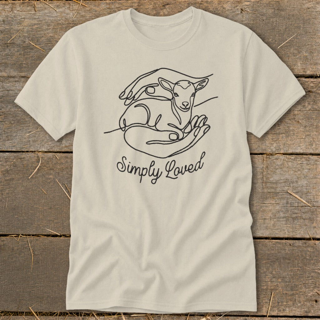 Light beige t-shirt with line art of hands holding a lamb and text "Simply Loved".