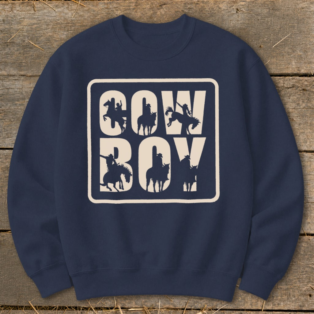 Navy sweatshirt with "COW BOY" text and cowboy silhouettes in a cream box.