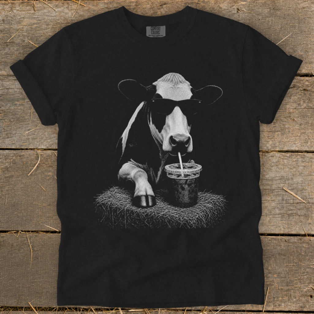 Black t-shirt with graphic of a cow wearing sunglasses drinking from a cup.