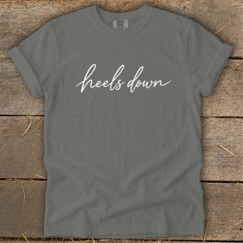 Grey t-shirt with white cursive text "heels down" and a Comfort Colors tag.