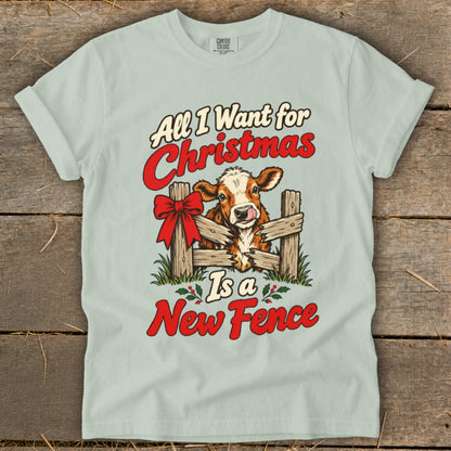 T-shirt graphic with cow behind fence and text "All I Want for Christmas Is a New Fence".