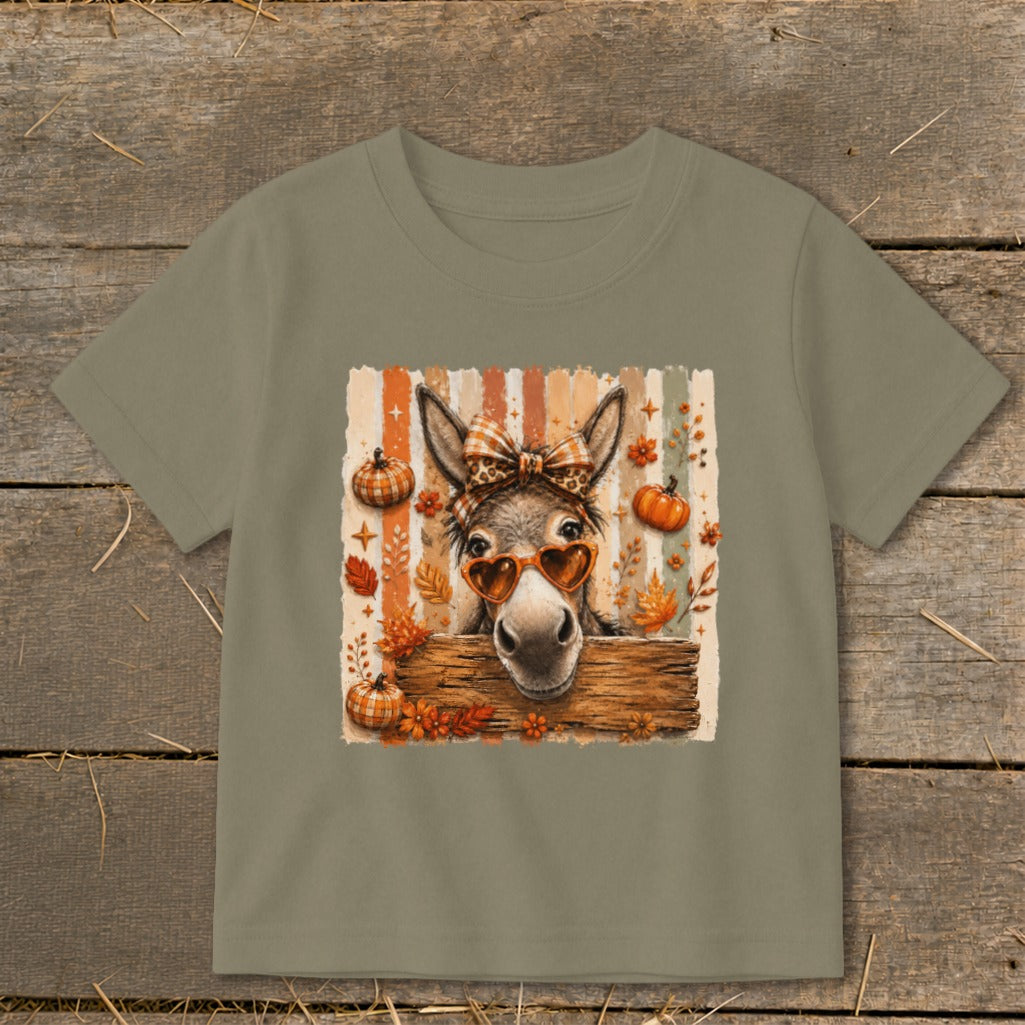 Donkey wearing heart sunglasses and bow, with pumpkins and fall leaves.