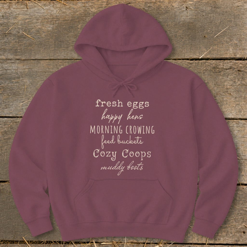 Maroon hoodie with text: fresh eggs, happy hens, morning crowing, feed buckets, cozy coops, muddy boots.