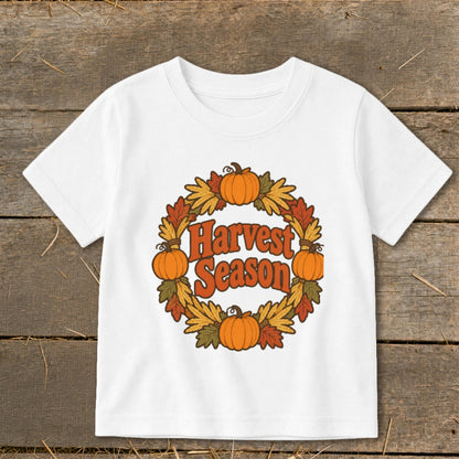 White t-shirt with a circular fall leaf wreath and pumpkins, text "Harvest Season".