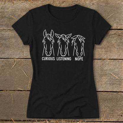 A black short-sleeved t-shirt featuring three horse head illustrations with the captions Curious, Listening, and Nope.