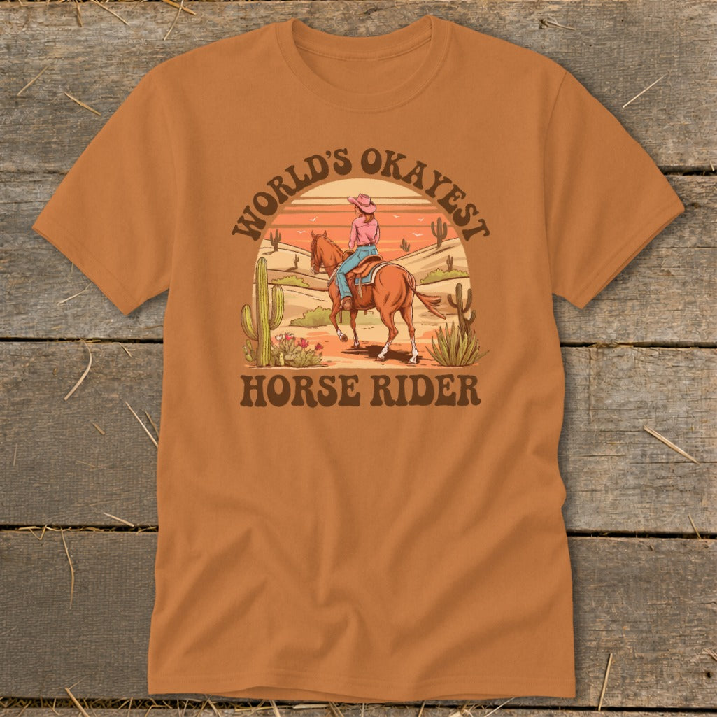 Orange t-shirt with "World's Okayest Horse Rider" text and desert scene graphic.