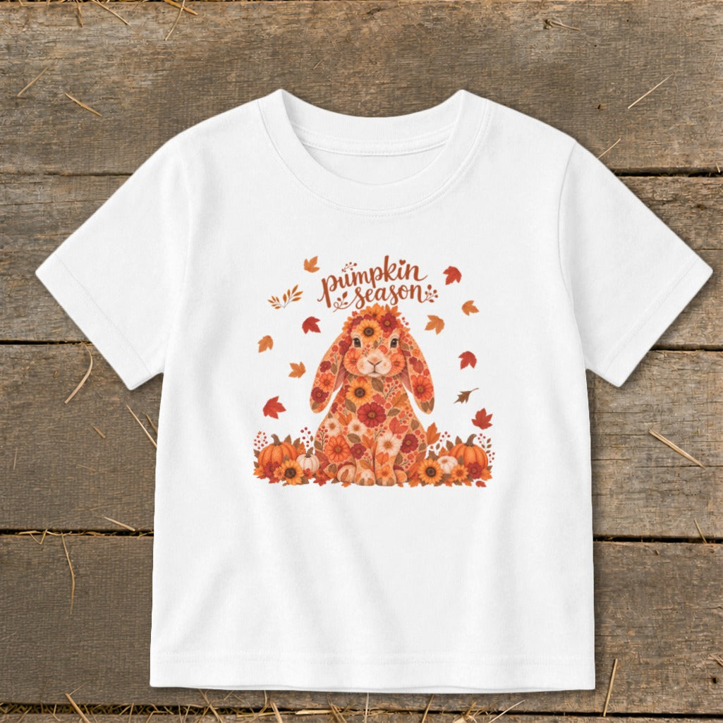 White t-shirt with a floral bunny and "pumpkin season" text among autumn leaves.