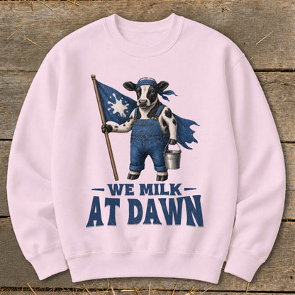 Pink sweatshirt with graphic of cow in overalls holding flag and bucket, "We Milk At Dawn" text.