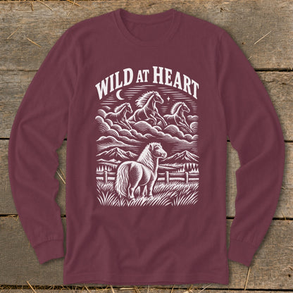 Maroon long-sleeve t-shirt with a white graphic of horses, mountains, and the text "Wild At Heart".
