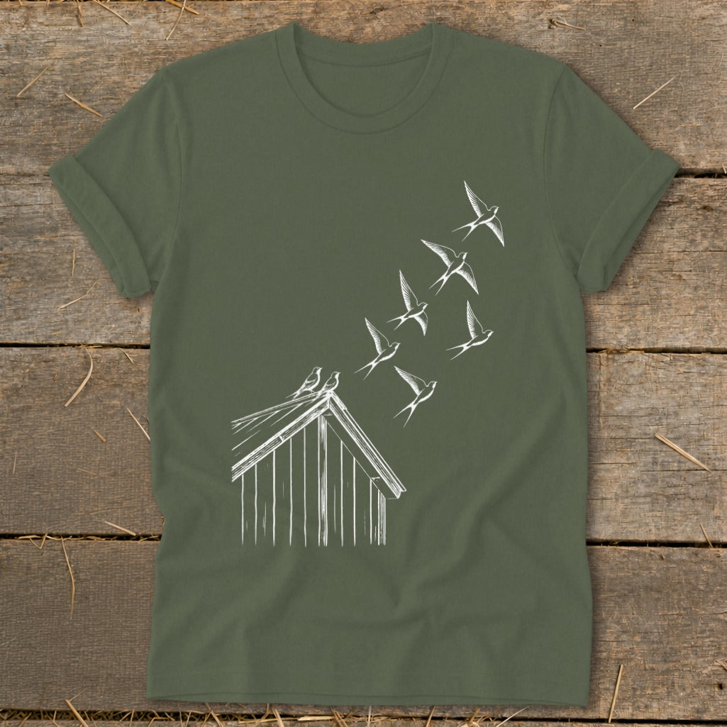 Olive green t-shirt featuring a white line drawing of a flock of swallows flying from a rooftop.