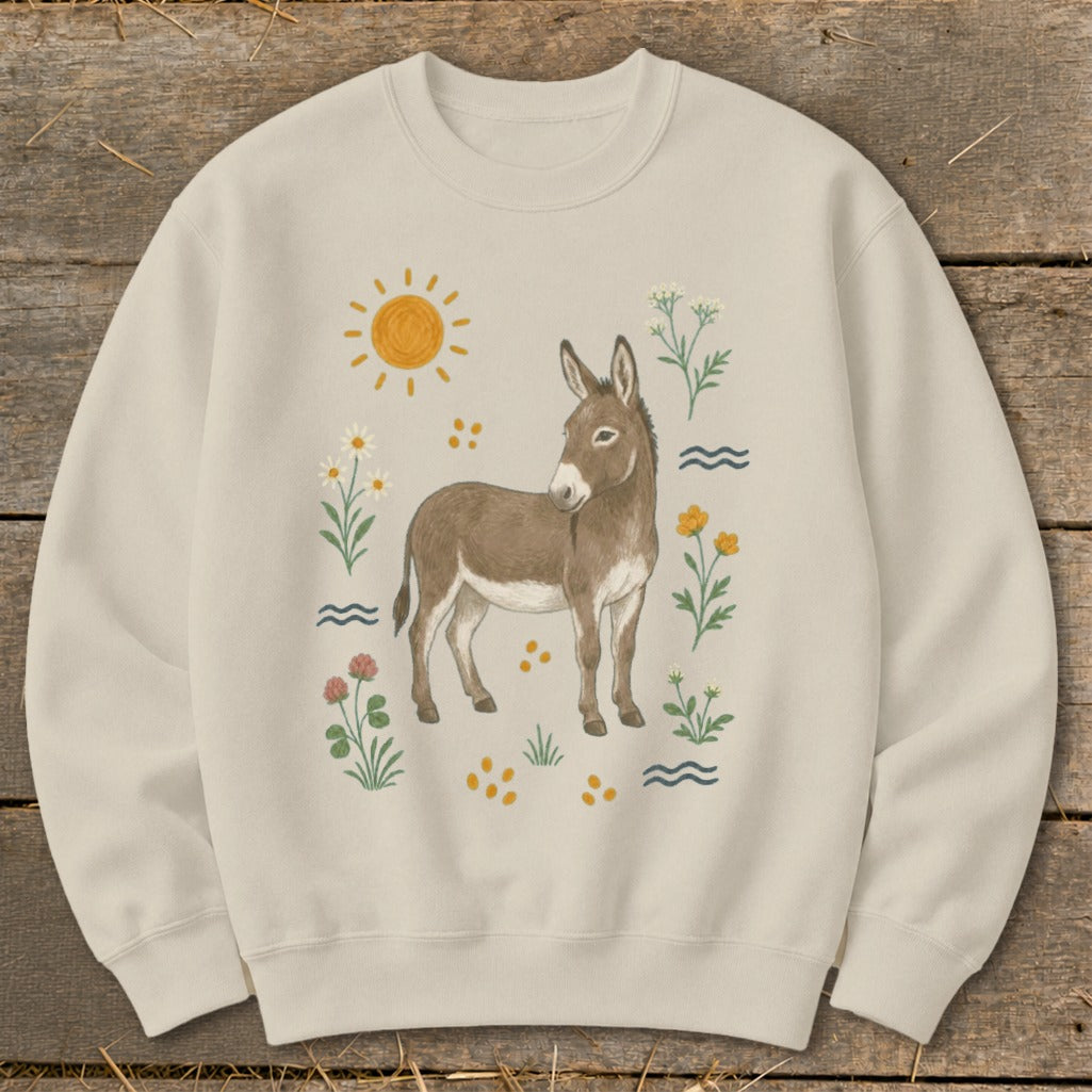 Cream sweatshirt with a brown donkey and floral illustration, sun, and wavy lines.
