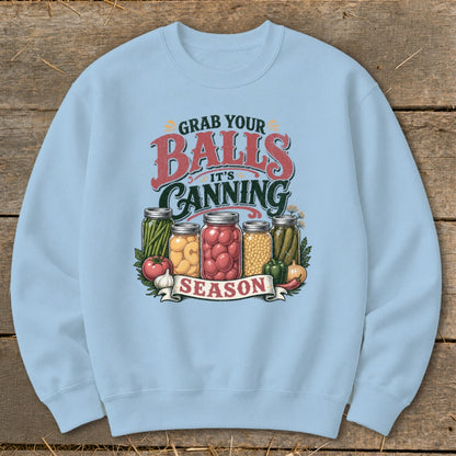 Light blue sweatshirt with "Grab Your Balls It's Canning Season" graphic and jars of produce.