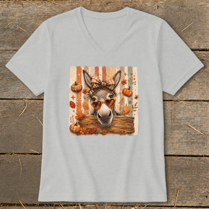 Donkey wearing heart sunglasses and bow on pastel striped background with pumpkins.