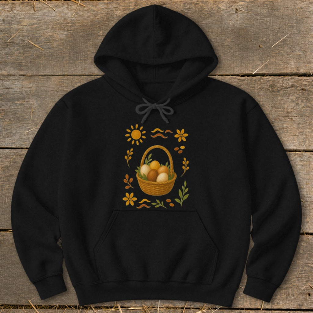 Black hoodie with a central design of a wicker basket filled with eggs and surrounding floral and sun elements.