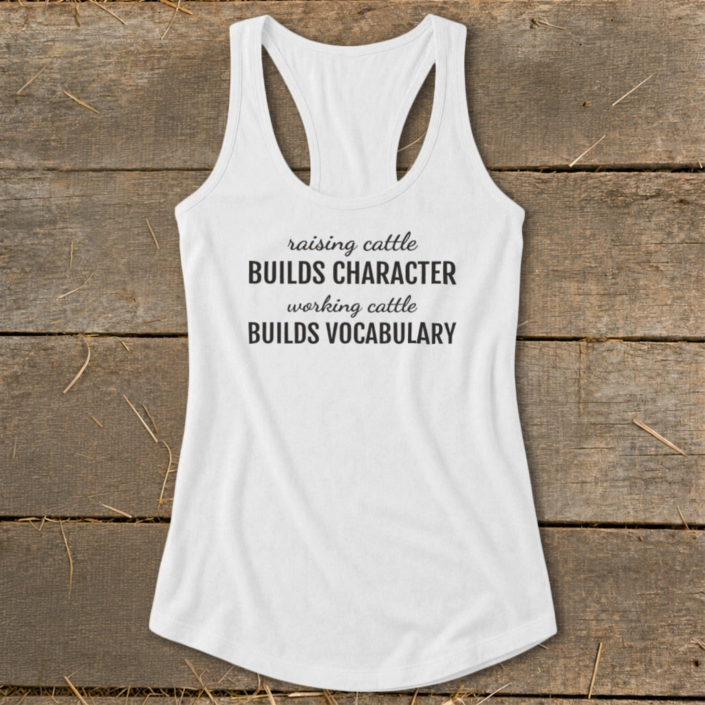White tank top with text: raising cattle BUILDS CHARACTER working cattle BUILDS VOCABULARY.