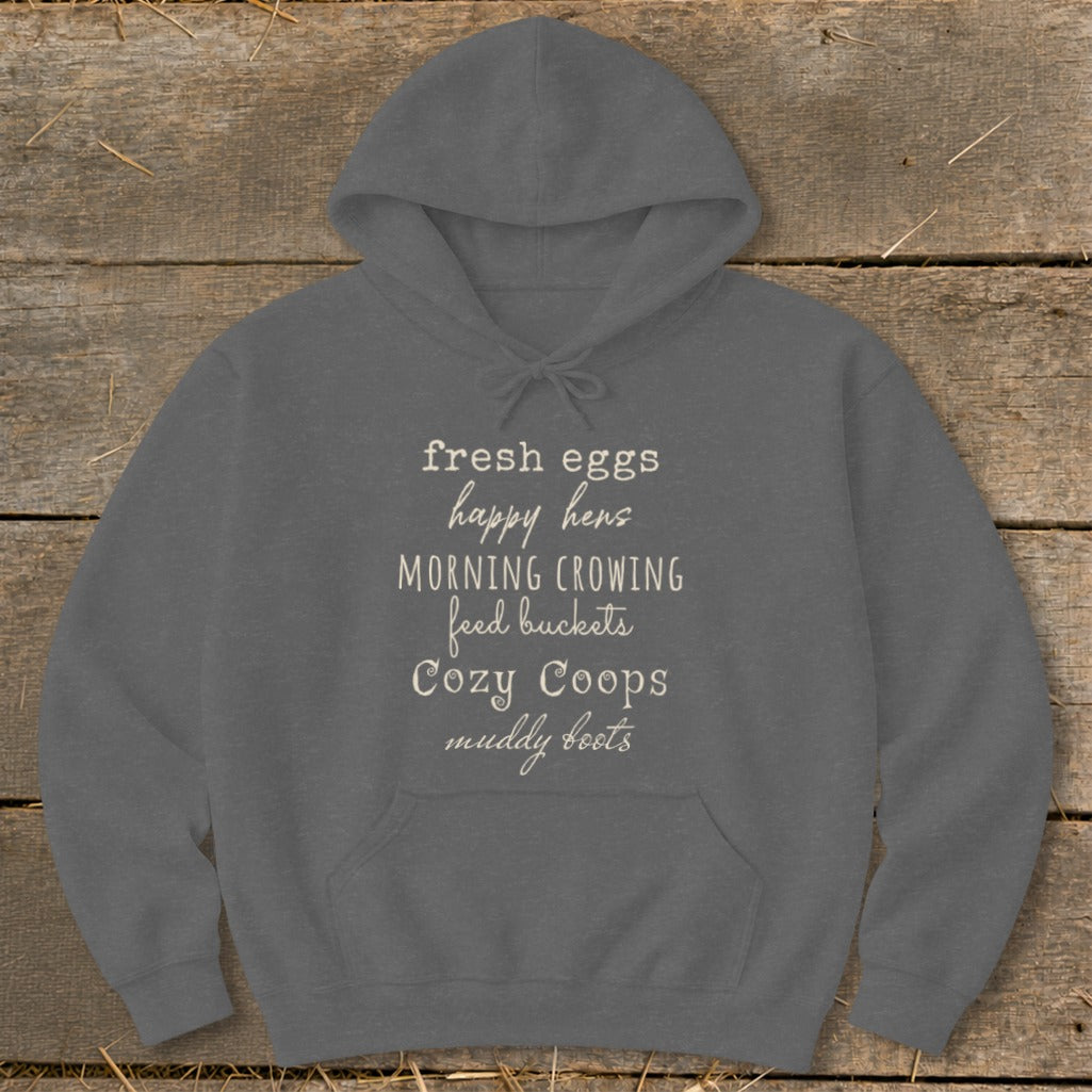 Gray hoodie with "fresh eggs, happy hens, morning crowing, feed buckets, cozy coops, muddy boots" text.