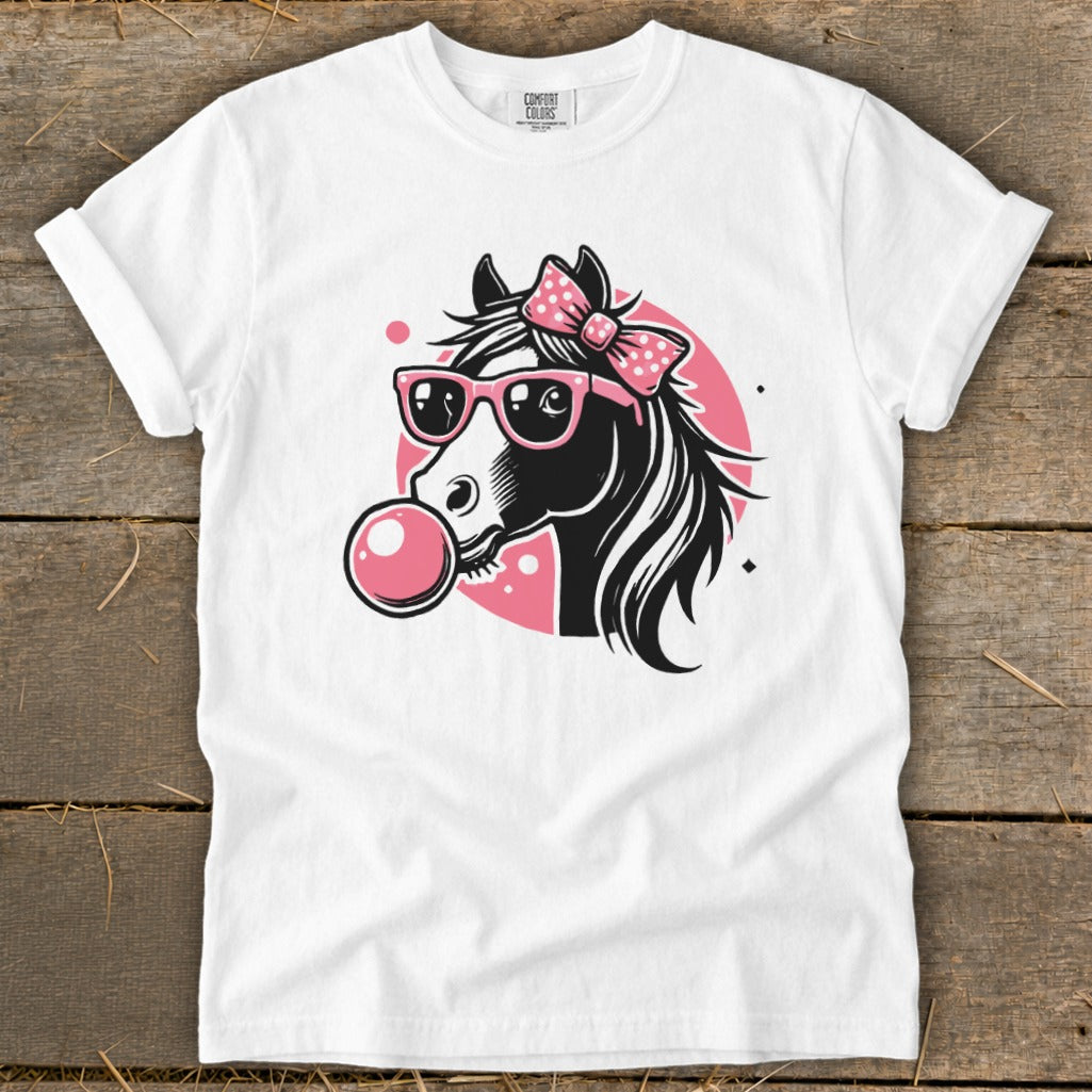 White t-shirt with a graphic of a black horse wearing pink sunglasses and a pink bow, blowing bubblegum.